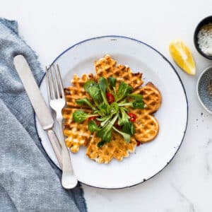 A plate of cheese waffles served with greens.
