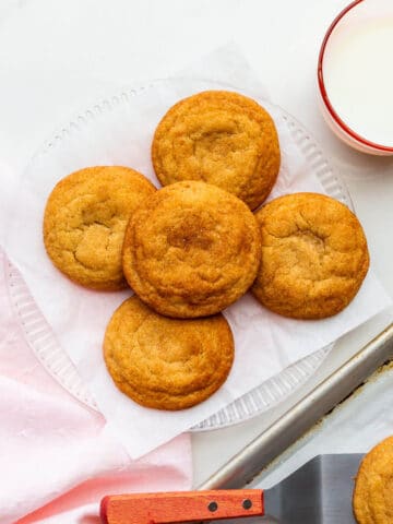 A plate of freshly-baked homemade snickerdoodles transferred from the cookie sheet with a spatula.