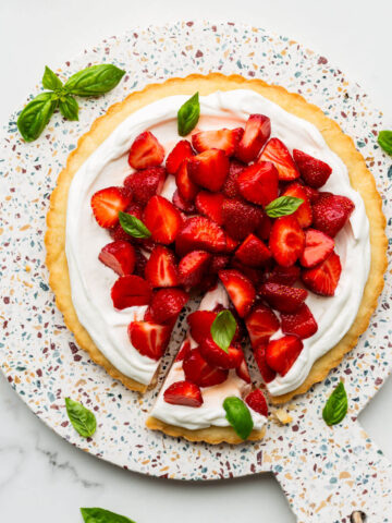 Serving a strawberry cream tart on a terrazzo board.