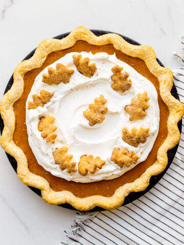 Sweet potato pie topped with whipped cream and grated nutmeg.