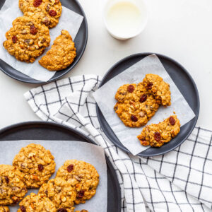 Plates of oatmeal raisin cookies served with milk.