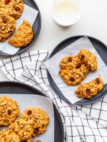 Plates of oatmeal raisin cookies served with milk.