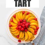 An image of a pistachio tart topped with slices of peaches and raspberries being served. Text overlay says "Pistachio tart".