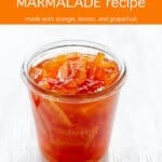 A glass Weck jar filled with lemon orange grapefruit marmalade (3 fruit marmalade) very vibrant orange marmalade colour with thick pieces of peel
